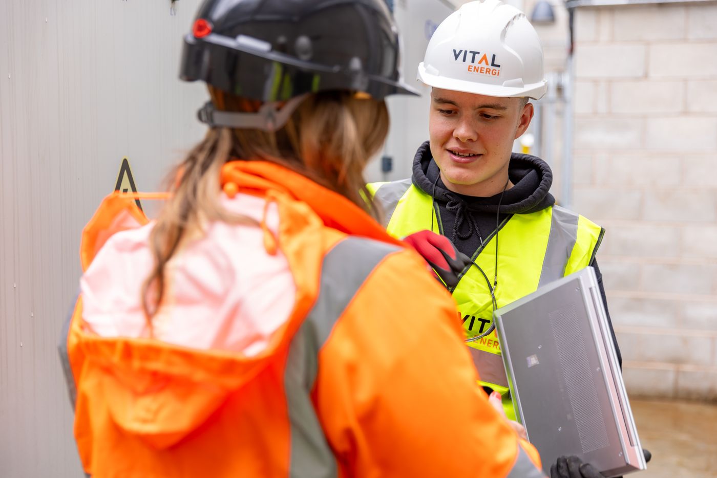 Young construction apprentices in hi-vis on site
