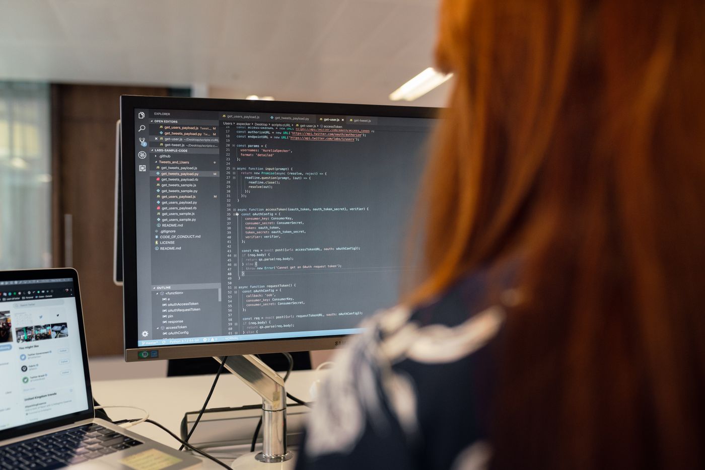 Young woman writing code in a modern office